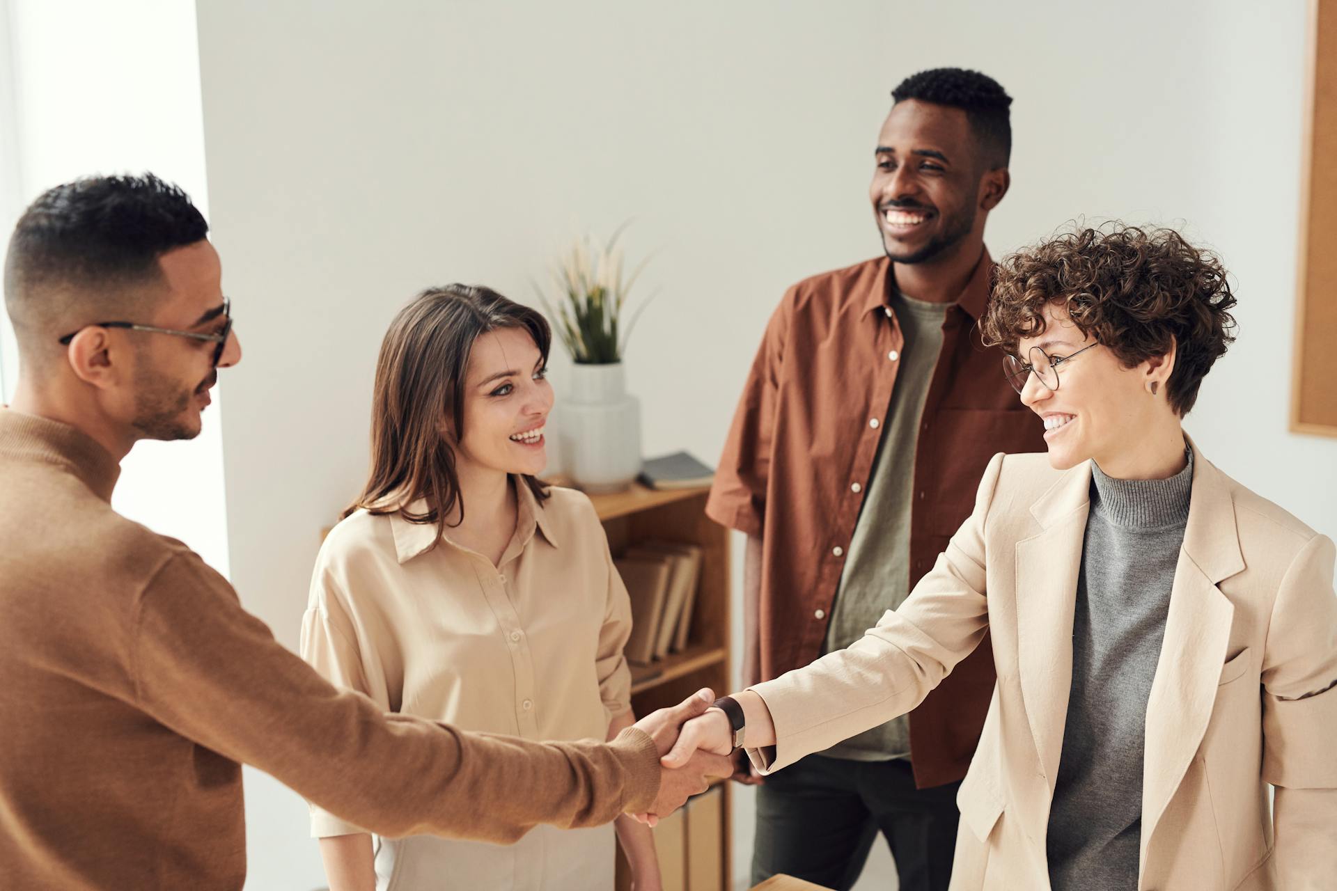 Equipe de colaboradores aperta as mãos como forma de representar o Setembro Amarelo nas empresas.
