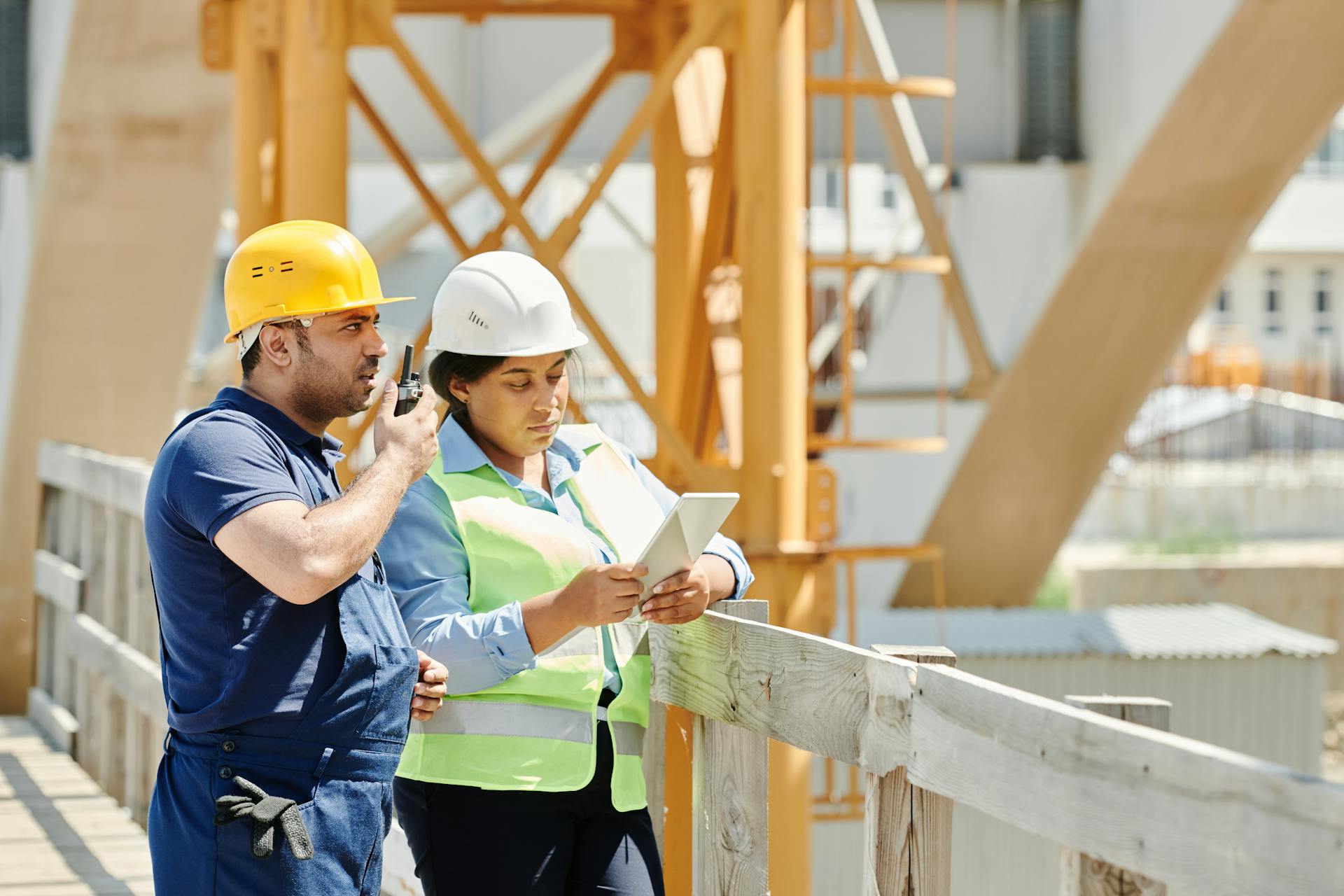 Trabalhadores dialogando em obra representam treinamentos sobre segurança do trabalho.